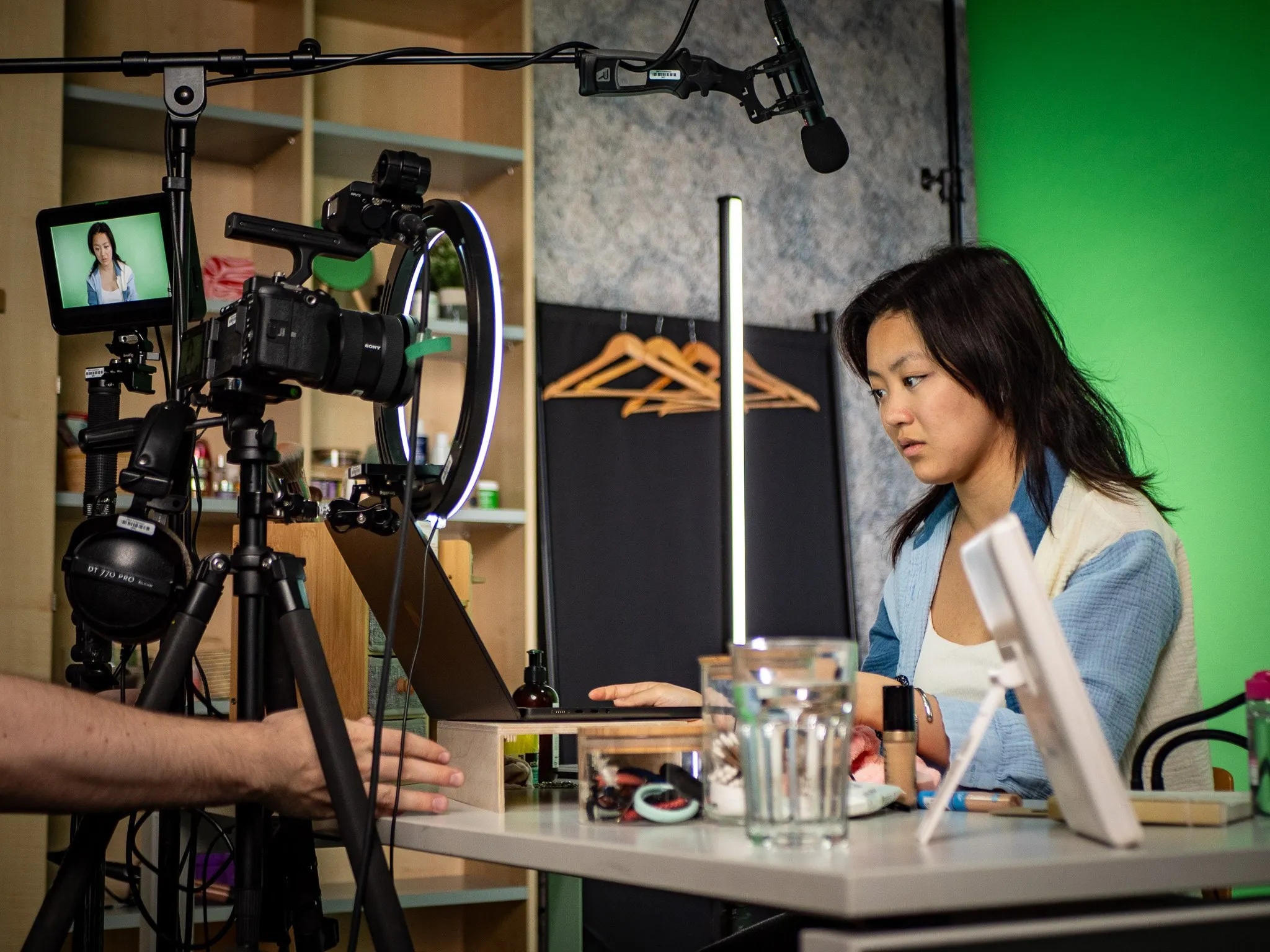Studiodreh: Darstellerin vor Kamera und Ringlicht am Greenscreen-Set