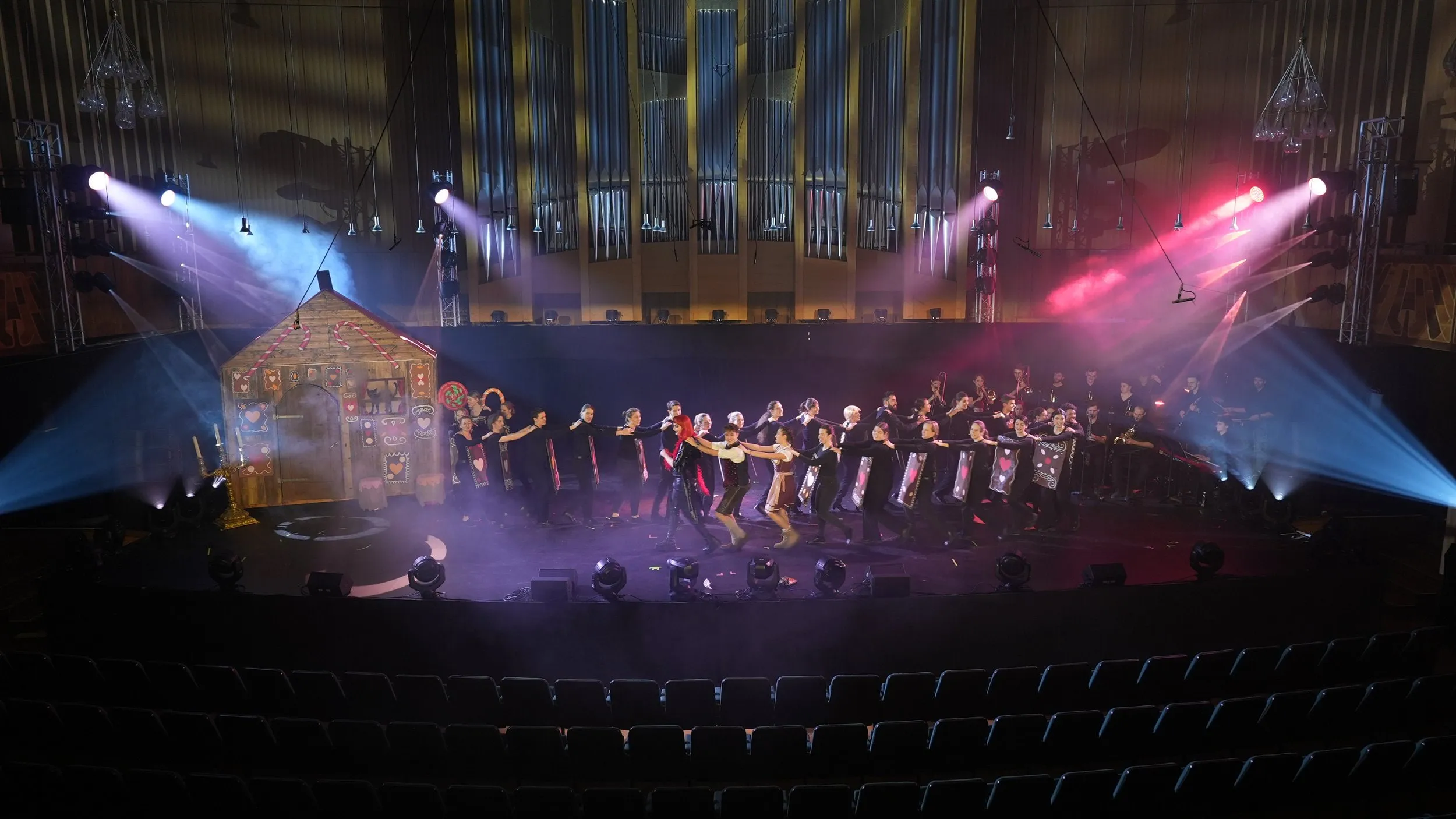 Konzertsaal mit Bühnenkulisse, Ensemble und farbiger Lichtshow