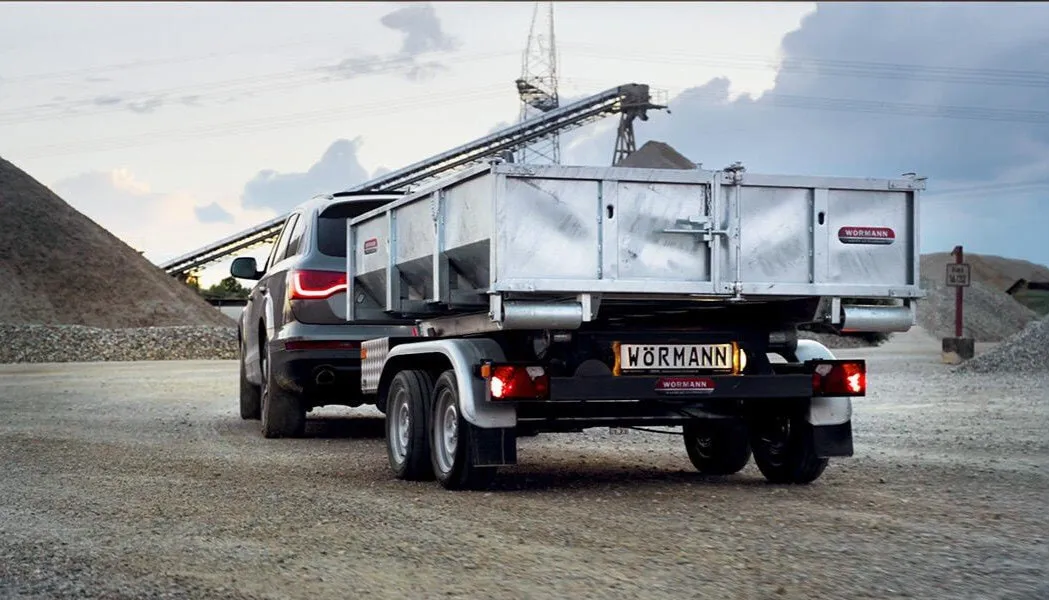 Geländewagen mit Wörmann-Anhänger vor einem Kieswerk