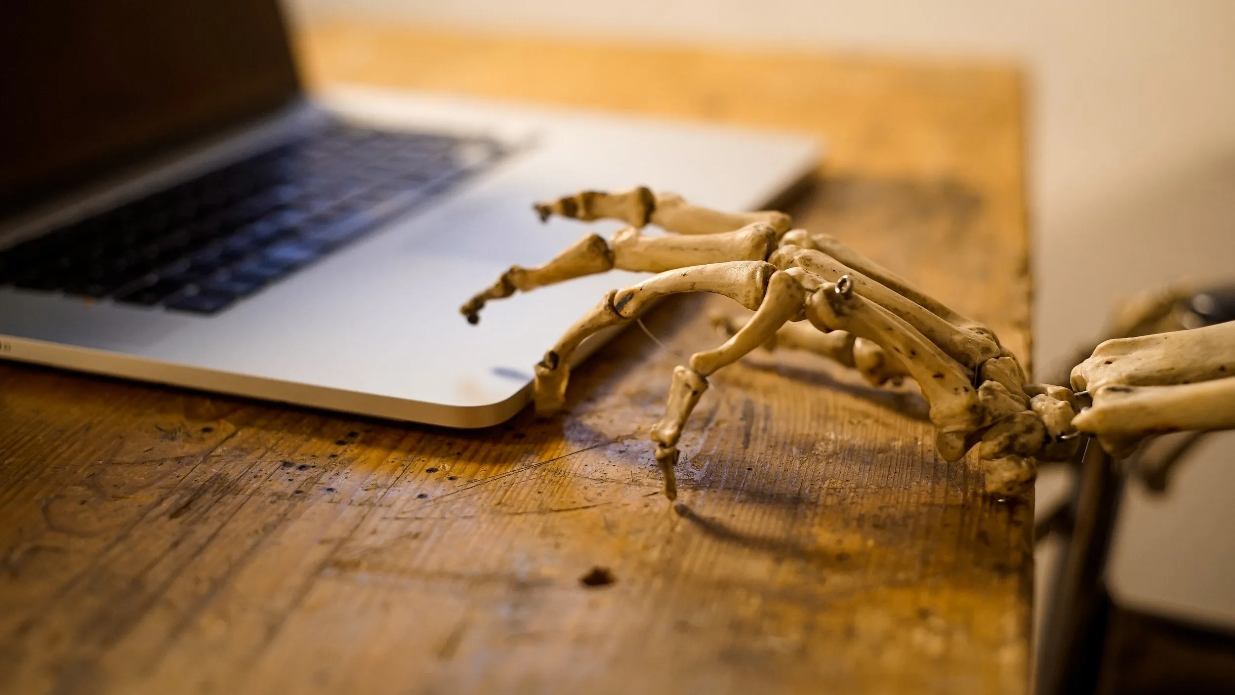 Skeletthand als Requisite liegt auf einem Laptop