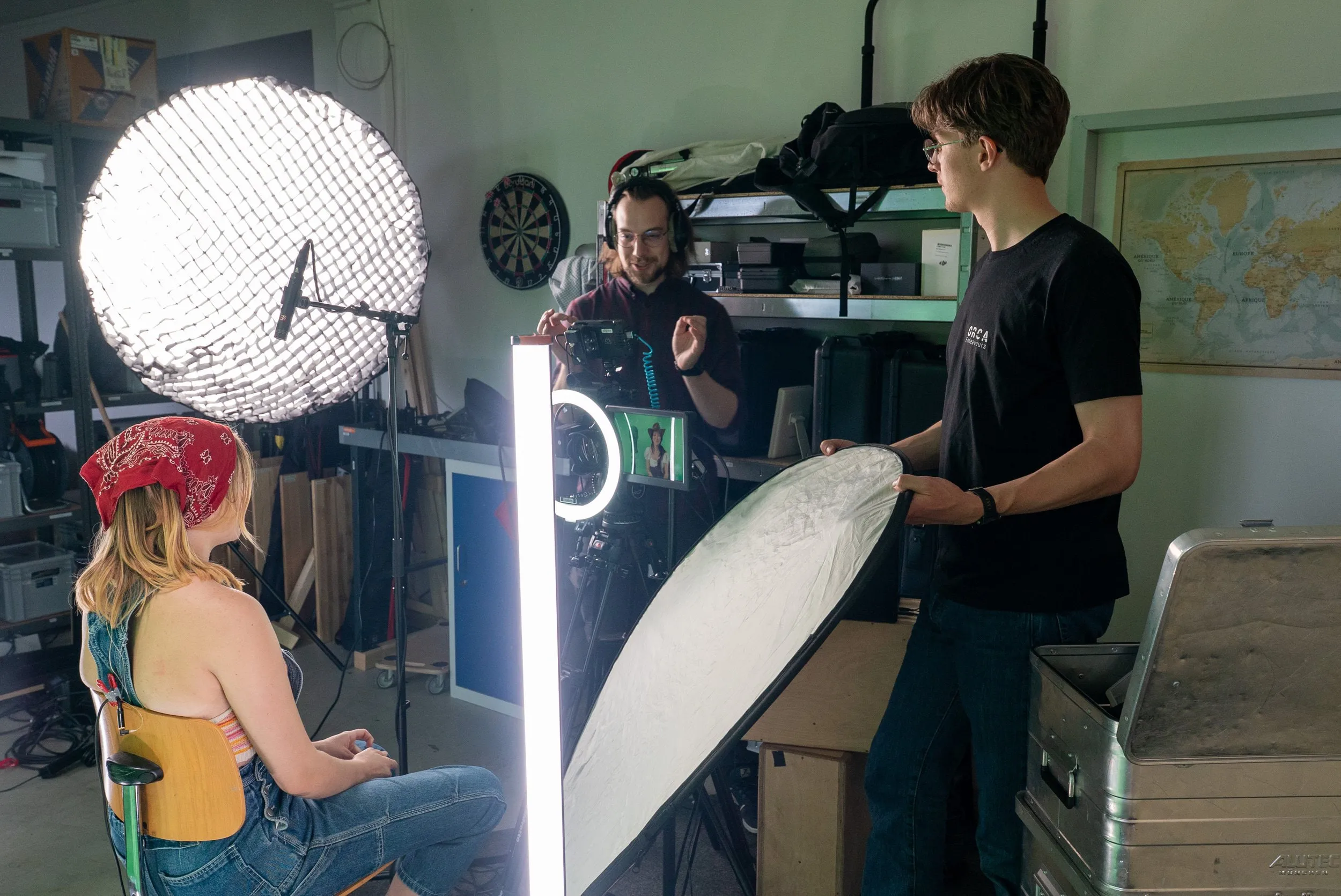 Lichtaufbau mit Softbox und Leuchtstab, im Vordergrund die Darstellerin mit rotem Kopftuch