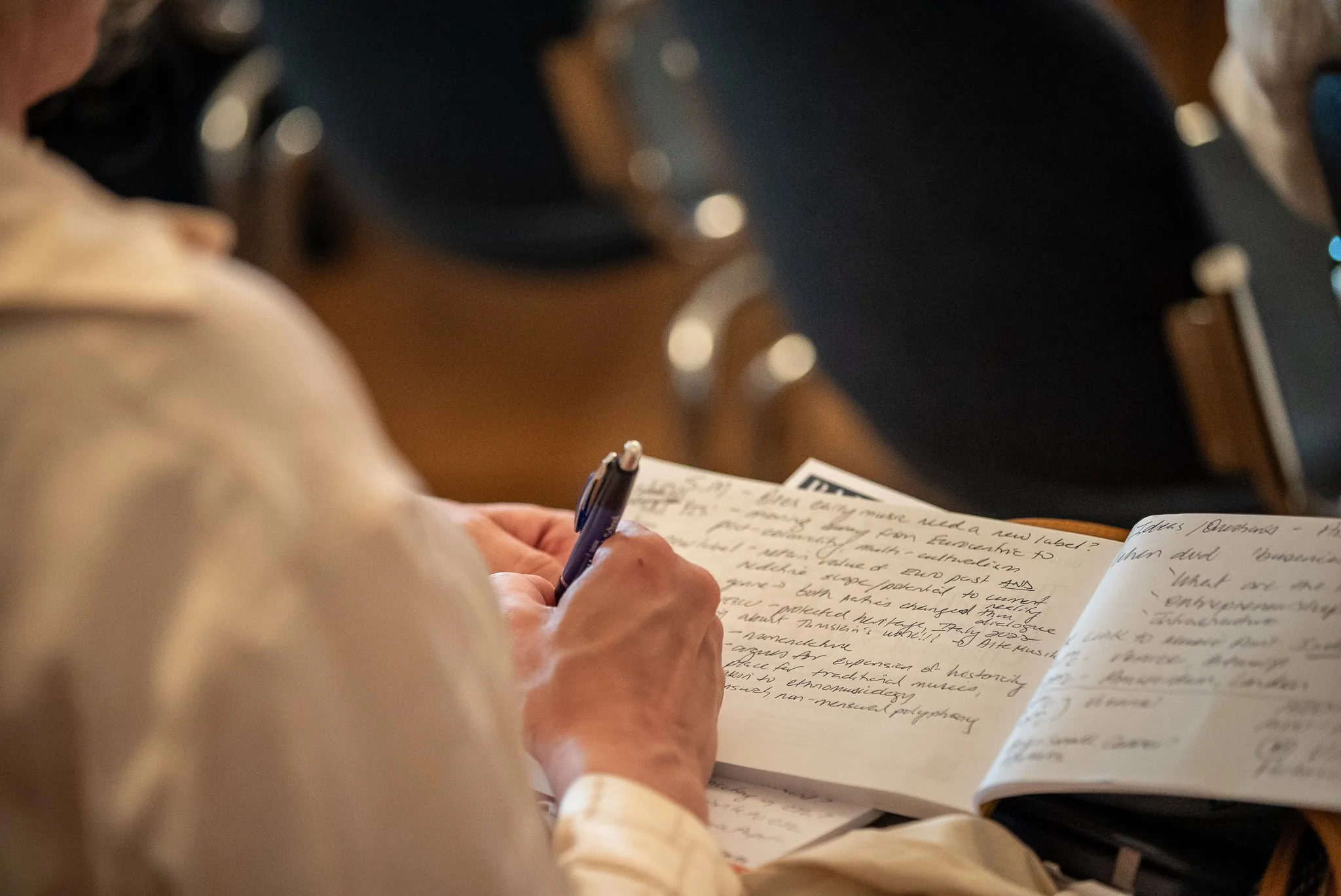 Person schreibt handschriftliche Notizen in ein Heft