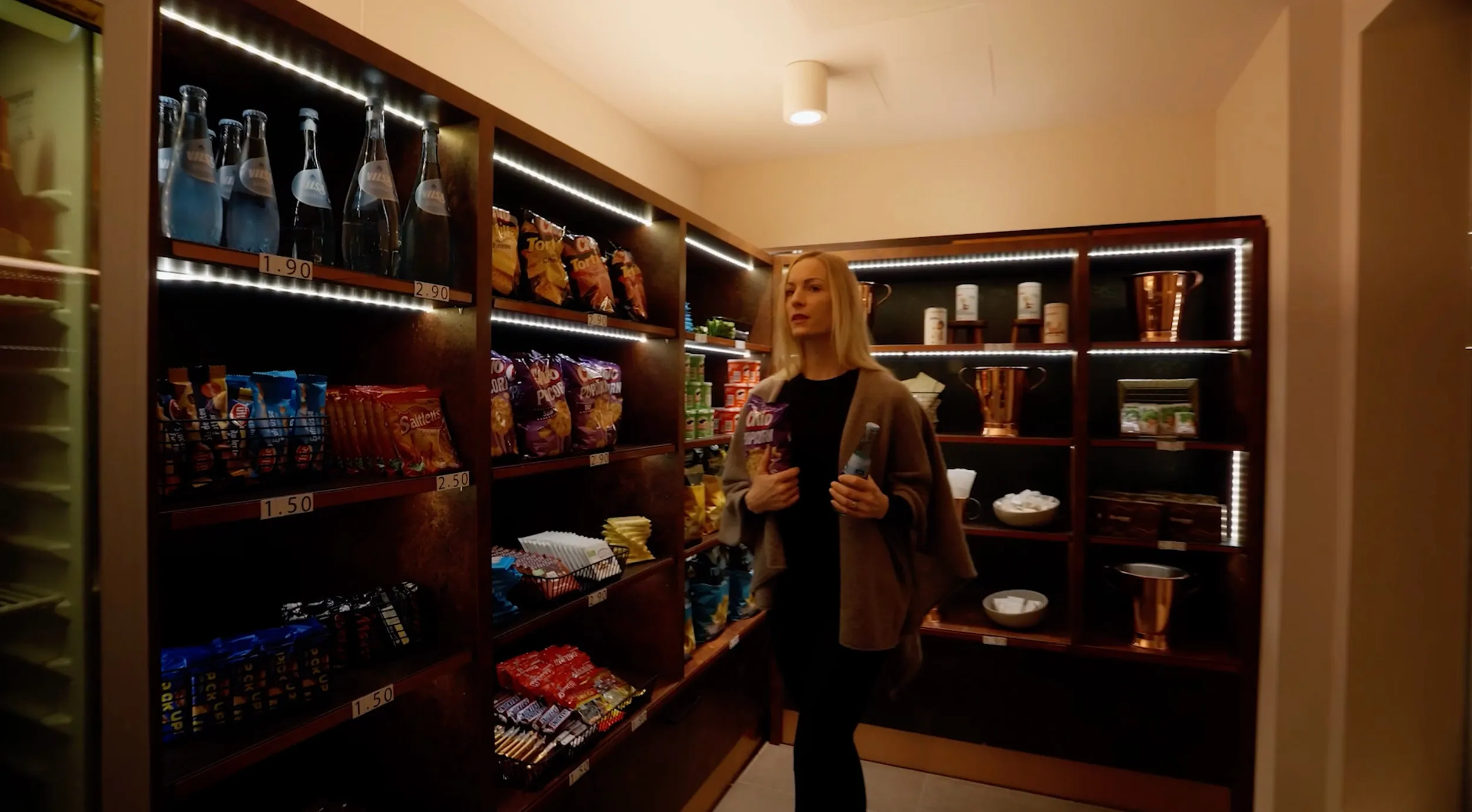 Frau im hotelinternen Markt vor Regalen mit Getränken und Snacks