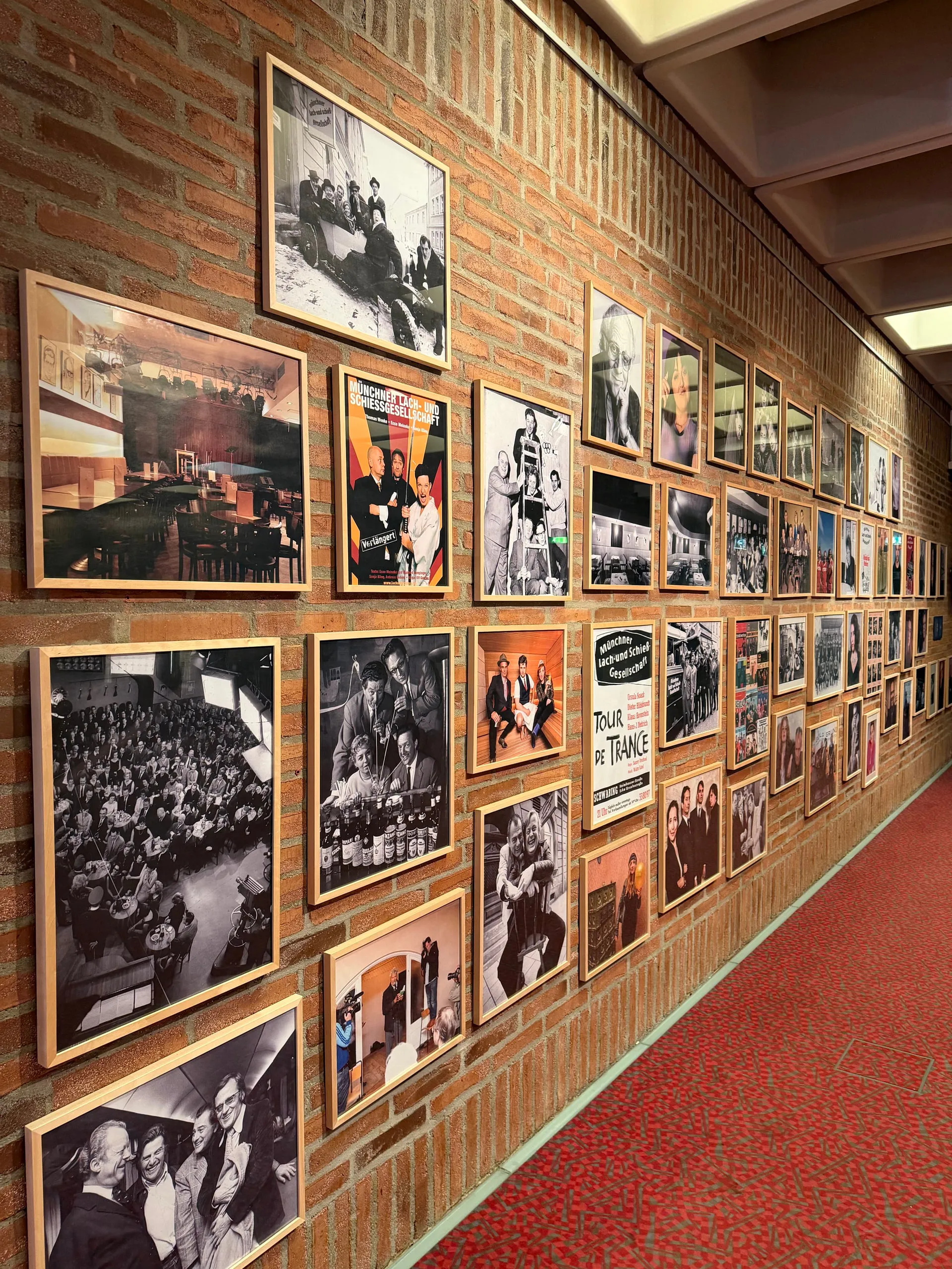 Wand mit gerahmten historischen Fotos und Plakaten in der Lach- und Schießgesellschaft