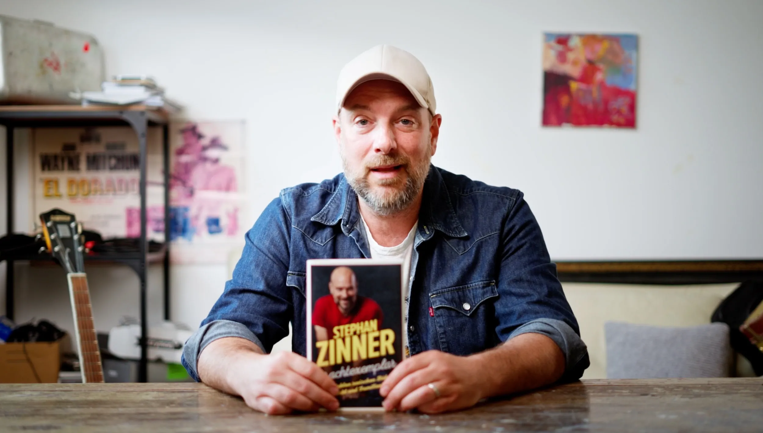 Mann mit Buch am Tisch – Interview-Setting in einer Werkstatt