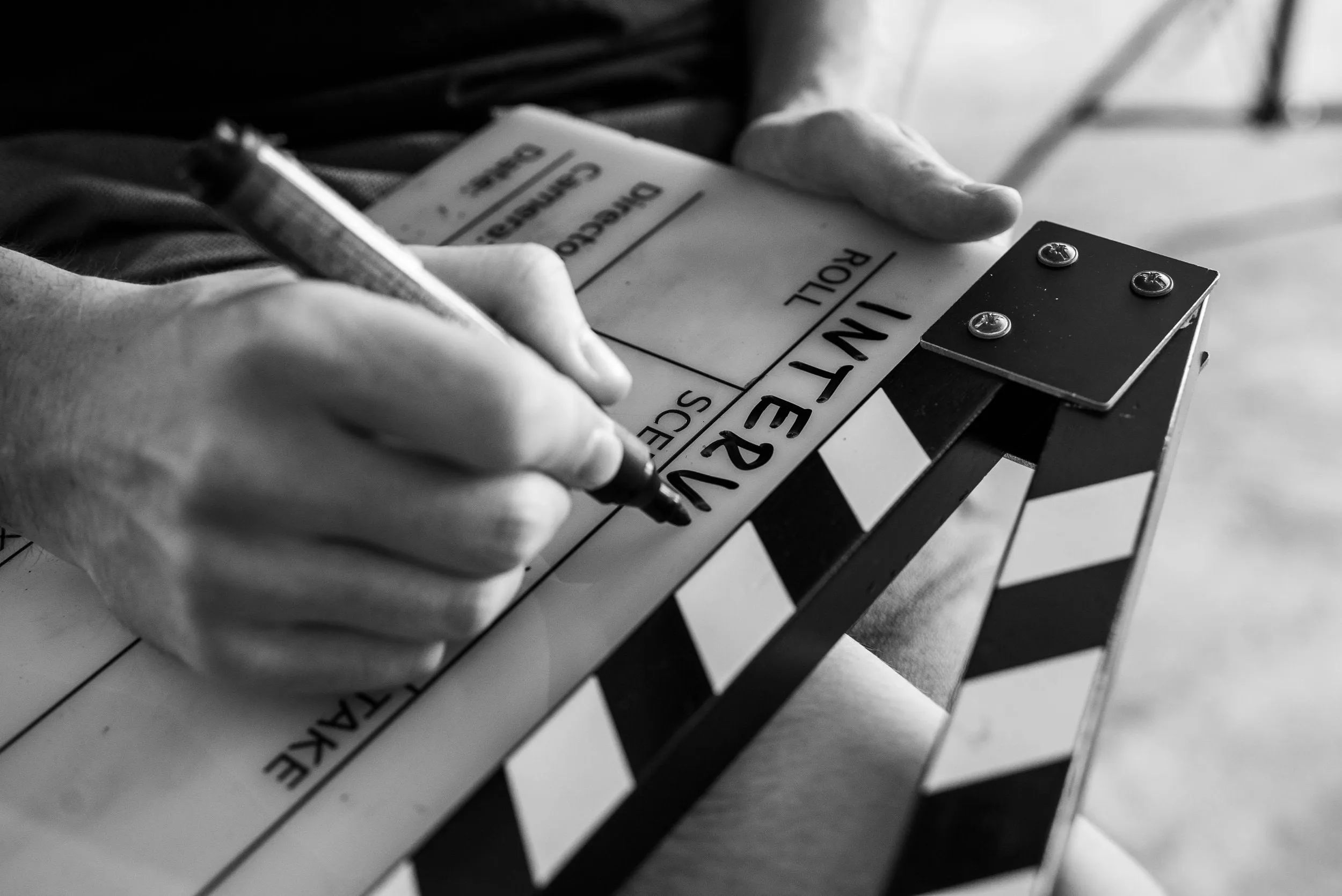Hand beschriftet eine Filmklappe für ein Interview