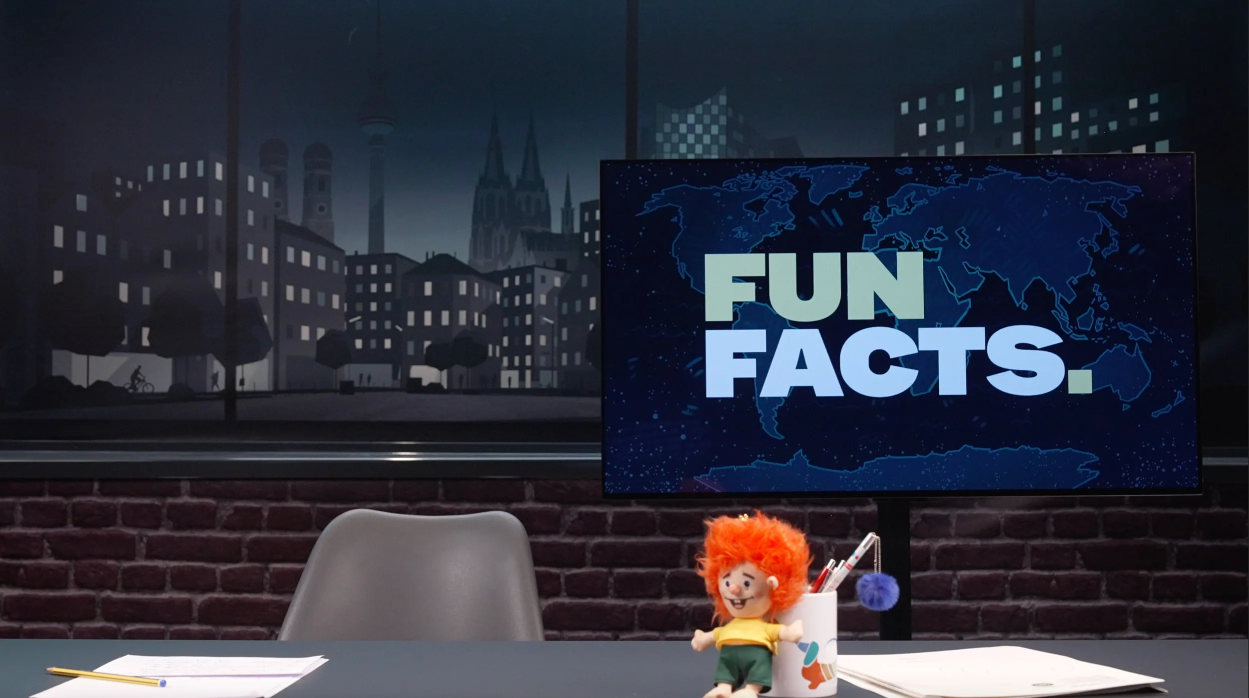 Studioset von Fun Facts mit nächtlicher Stadtkulisse, Bildschirm mit Fun-Facts-Logo und Moderationstisch
