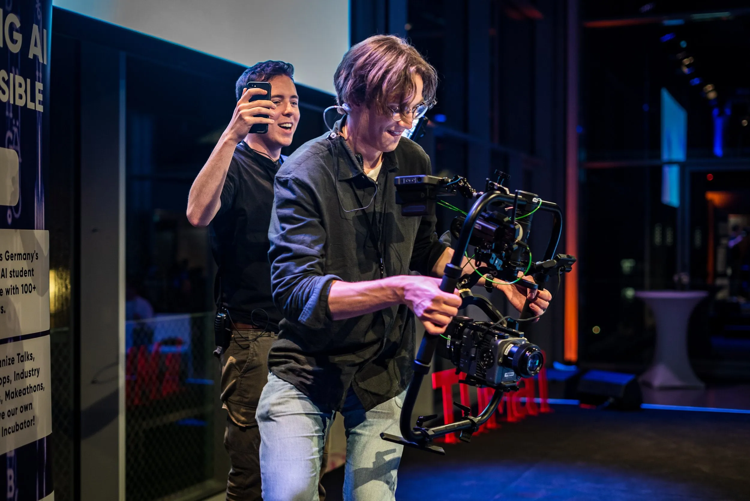 Zwei Kameraleute filmen bei einer Veranstaltung mit Gimbal und Smartphone