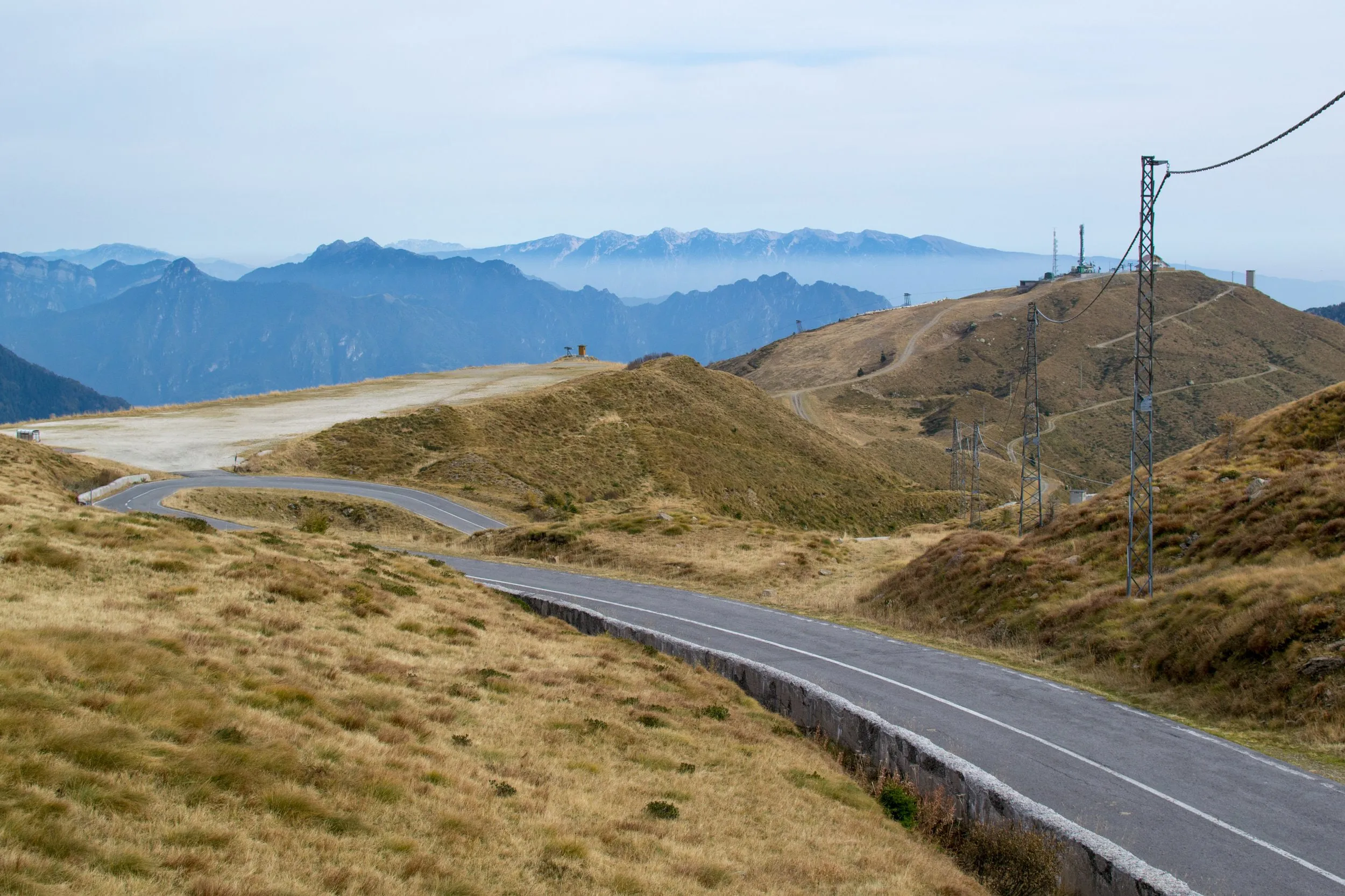 Kurvige Bergstraße durch karge, braune Hügel am Giogo del Maniva