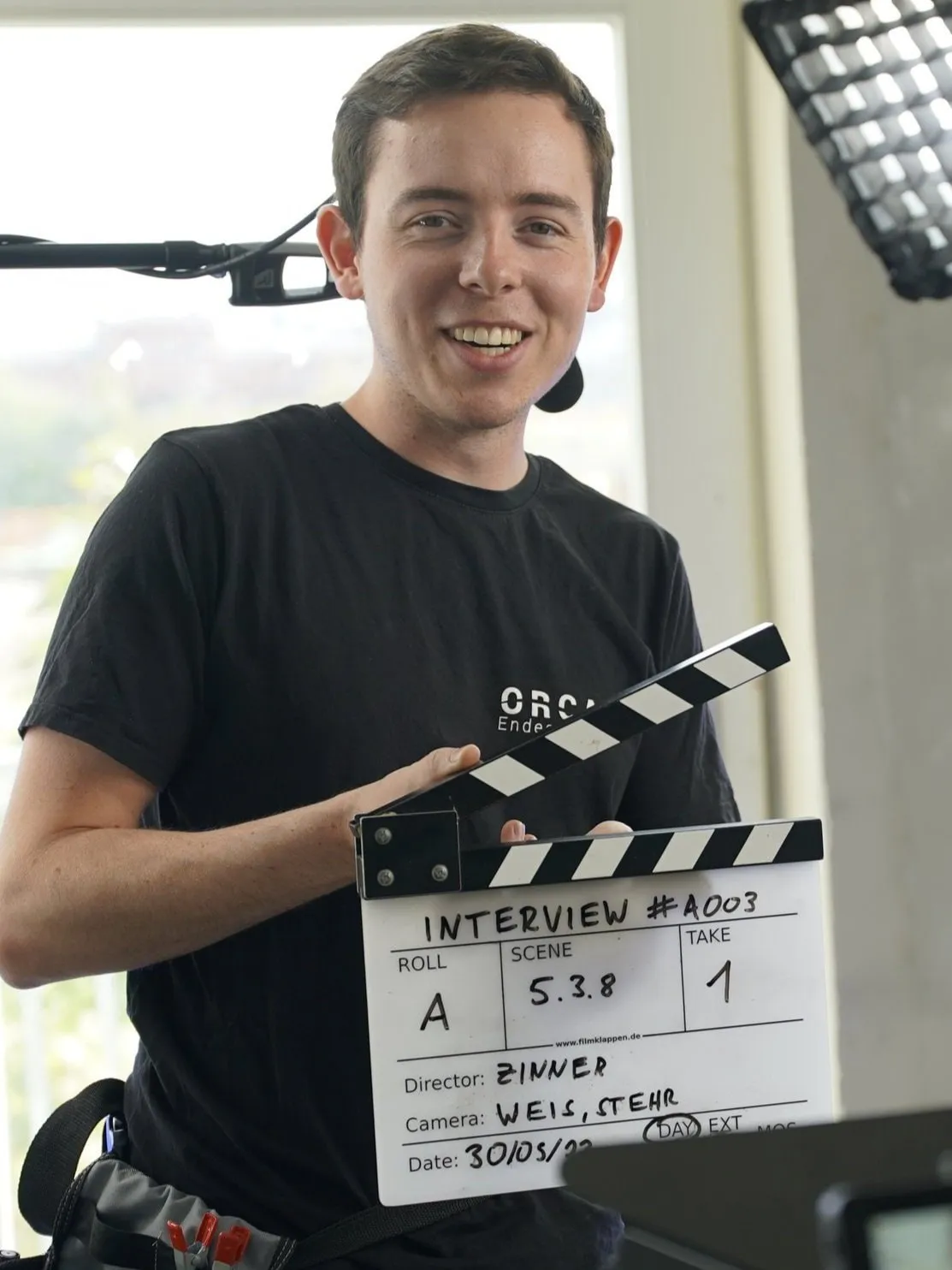 Portrait von Benjamin Stehr mit Filmklappe